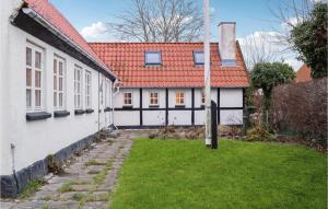 Kirke SåbyAmazing Home In Kirke Sby With Kitchen的白色的房子,有红色的屋顶和院子