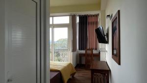 康提Sun Dove Suite的客房设有窗户、床和电视。