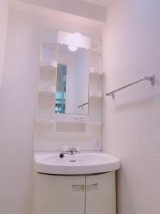 福冈Picolo Hakata的白色的浴室设有水槽和镜子