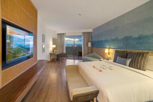 邦劳Modala Beach Resort的酒店客房设有一张大床和一张沙发。