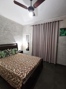 阿拉鲁阿马Flat Gorlaes的一间卧室配有一张床和吊扇