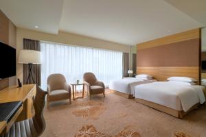 成都成都首座万丽酒店的酒店客房设有两张床和一台平面电视。