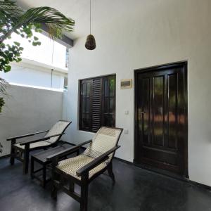 阿鲁甘湾Agra Arugambay的门廊配有两把椅子和一扇门