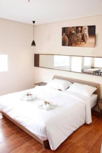雅加达AZKA HOTEL Managed by Salak Hospitality的卧室内的两张床,配有白色床单