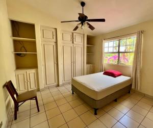 马那瓜SAM TRAVEL的一间卧室配有一张床、风扇和椅子