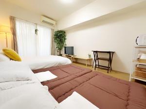 福冈Picolo Hakata的酒店客房,设有两张床和一张沙发