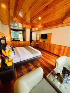 马拉里Himalayan Nature Walk Resort, Manali的一间卧室配有一张床和一个沙发