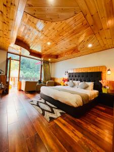 马拉里Himalayan Nature Walk Resort, Manali的一间卧室设有一张带木制天花板的大床