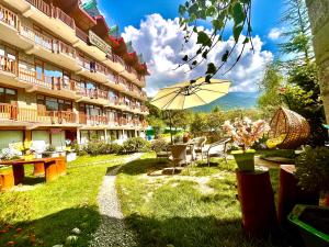 马拉里Himalayan Nature Walk Resort, Manali的酒店庭院配有桌子和遮阳伞