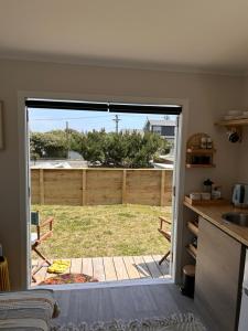 Otaki BeachKowhai Landing Beach Cabin的厨房设有通往庭院的门