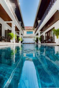 琅勃拉邦Cozy An Boutique Hotel Luangprabang的蓝色水中的酒店的游泳池