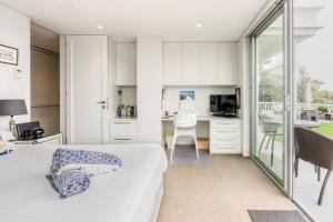 悉尼Balmoral Beach Beauty的一间带一张床和一张书桌的卧室和一间厨房