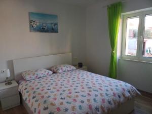 波斯蒂拉Apartment Perica - 10 m from sea的一间卧室配有一张带床罩的床和窗户