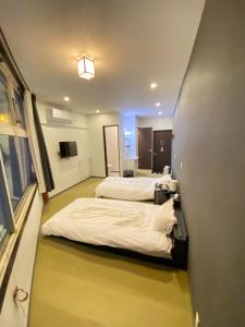Nakamachiロマンスホテル（Romance Hotel）的一间酒店客房,设有两张床和走廊