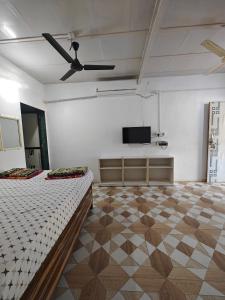 阿利鲍格Kulswami Cottage Alibaug的白色的客房配有床和平面电视。