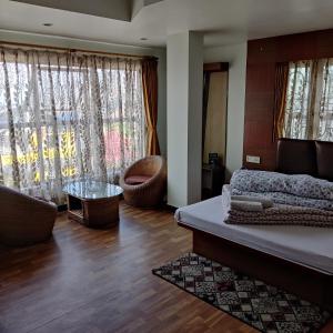 噶伦堡Hotel Mountain View的一间卧室设有一张床和一间客厅。