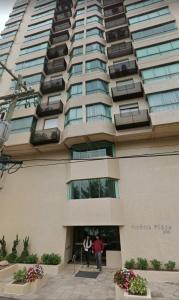 卡庞达卡诺阿Apartamento Beira mar Capão da Canoa的两个人站在高楼外