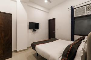 Vibhuti KhandInsight Inn Near Gomti Riverfront Park的一间卧室配有一张床和一台平面电视