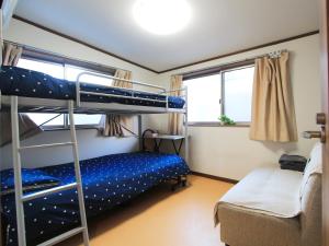 东京和貴ビル的一间带两张双层床和一张沙发的卧室