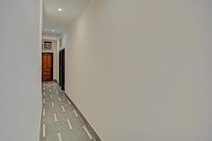 ShāhdaraOYO Hotel Jmd Residency的走廊上设有白色的墙壁和地板