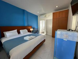 清莱开奥祖母之家酒店的一间卧室设有一张蓝色墙壁的大床