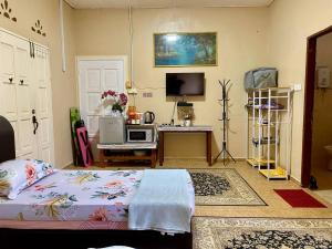 加央COZY GL Roomstay ARAU的一间卧室配有一张床和一张书桌及电视