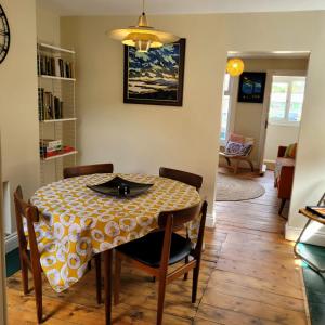 凯辛兰Pea Cottage的餐桌,配有黄色和白色的桌布