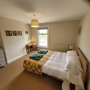 凯辛兰Pea Cottage的一间卧室配有一张床、一张书桌和一个窗户。