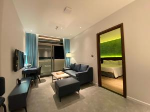 广义NEWCC HOTEL AND SERVICED APARTMENT的带沙发、床和镜子的客厅