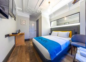 伊斯坦布尔塔克西姆大街公寓的一间卧室配有一张特大号床和一张蓝色椅子