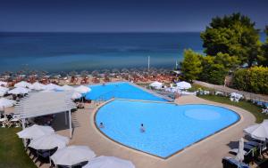 尼坡帝伊斯申俱乐部Spa酒店的享有带遮阳伞的游泳池和大海的顶部景致