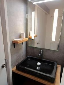 葱仁谷Val Thorens Studio 2 personnes et balcon Plein Sud的浴室设有黑色水槽和镜子