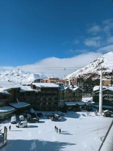 葱仁谷Val Thorens Studio 2 personnes et balcon Plein Sud的一群人,在建筑物前的雪中