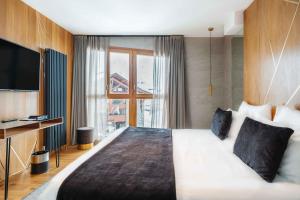 蒂涅Hôtel Le Diamond Rock的酒店客房设有一张大床和一台电视。