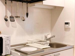 东京Dolce Shibuya的厨房配有水槽和墙上的餐具