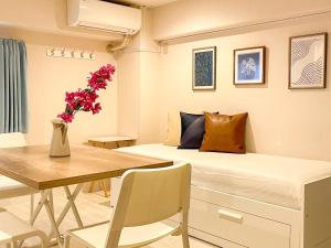 东京Dolce Shibuya的一间卧室配有一张床和一张花瓶桌子