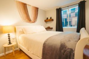 丹佛Windsor Retreat Private Basement Suite的卧室配有白色的床和窗户。