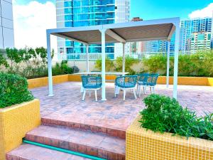 沙迦Luxury Apartment Al Khan Corniche View 2 BD的一个带蓝色椅子的庭院和一个凉亭
