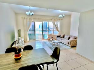 沙迦Luxury Apartment Al Khan Corniche View 2 BD的客厅配有桌子和沙发