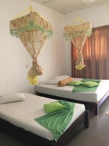 波隆纳鲁沃Polonnaruwa Holiday Inn的带窗帘的客房内的两张单人床