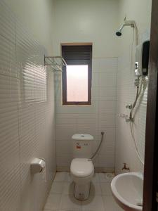 NamugongoTwinkle Blue Inn的白色的浴室设有卫生间和水槽。