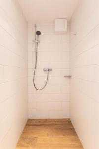 于斯德Haus Delft Argyra的白色瓷砖浴室内的淋浴