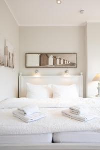 于斯德Haus Delft Lita的白色卧室配有白色床和毛巾