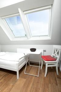 于斯德Haus Delft Ilmenau的客房设有床、书桌和窗户。