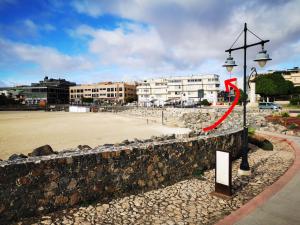 罗萨里奥港海滩附近2V豪华公寓 的红箭头指向海滩的街道灯