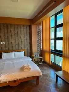 帕坦loo niva guest house studio apartment with balcony的一间卧室设有一张大床和一个大窗户