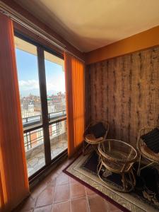 帕坦loo niva guest house studio apartment with balcony的客房设有带椅子和窗户的阳台。
