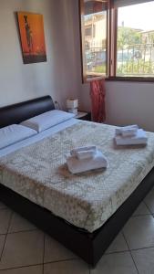 San SperateCasa Azzurra的一间卧室配有一张床,上面有两条毛巾