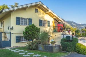 NovilleCheerful villa with fireplace, bath-tub and garden的蓝色百叶窗黄色房子