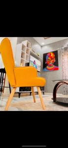Appart City Mbour的一张橙色椅子,放在带桌子的房间